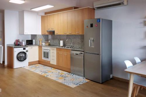 a kitchen with a stainless steel refrigerator and a dishwasher at Precioso apartamento duplex en el centro de Olot in Olot