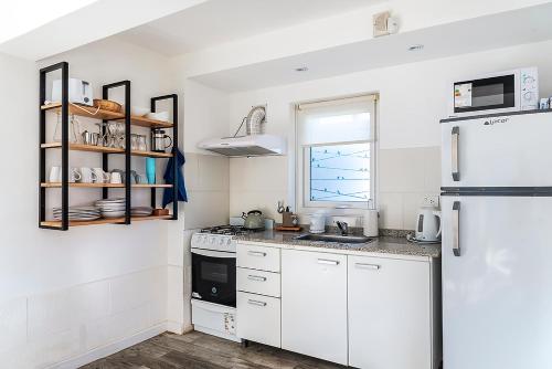 una cocina con electrodomésticos blancos y una ventana en Happy Host - Casas Calafate VLA en Villa La Angostura