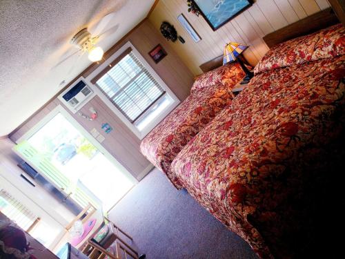a small bedroom with a bed and a window at Patras Grand Beach Motel in Old Orchard Beach