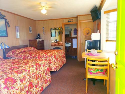a hotel room with two beds and a television at Patras Grand Beach Motel in Old Orchard Beach