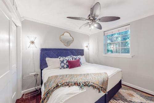 a bedroom with a bed with a ceiling fan at The Saint in Fayetteville