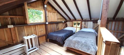 pokój z 2 łóżkami w drewnianym domu w obiekcie Cabañas Limón y Manzana en Finca Maracuba w mieście Jardin