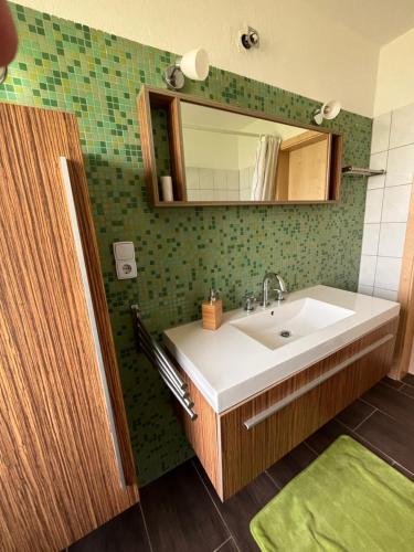 a bathroom with a sink and a mirror at Ruhige Ferienwohnung im Saarland in Schiffweiler