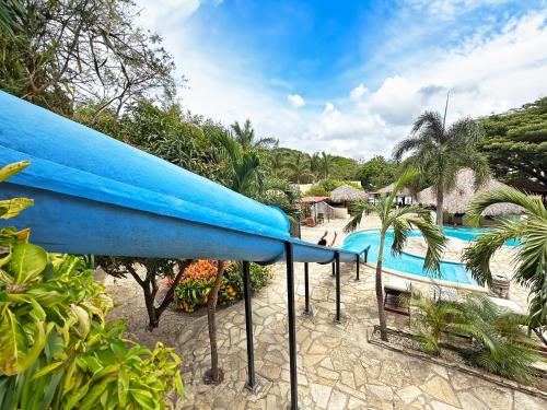 einen Pool mit blauem Surfbrett in einem Resort in der Unterkunft Surf Ranch Hotel & Resort in San Juan del Sur