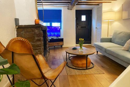 a living room with a couch and a table at 1750's cottage with open fire and beams in Upholland