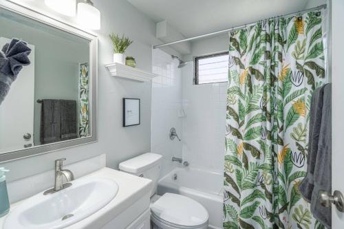 a bathroom with a sink and a toilet and a shower curtain at C7 Hono Kai in Wailuku