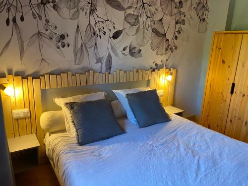 a bedroom with a bed with two blue pillows at gite moya in Gérardmer