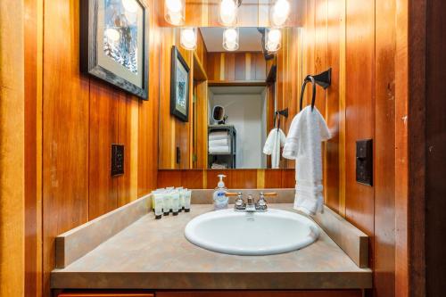 een badkamer met een witte wastafel en een spiegel bij Alyeska Slopeside in Girdwood