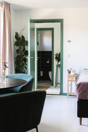 una sala de estar con una puerta que conduce a un baño en Bed & Bakkie Het Lamsoor Texel, en 't Horntje