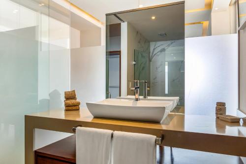 a bathroom with a white sink and a mirror at Harbor 171 Oceanfront Residences #13011 in Puerto Vallarta