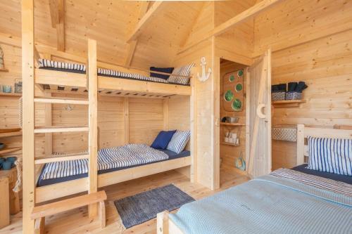 a bedroom with two bunk beds in a wooden cabin at Treehouse U lesa in Osečná
