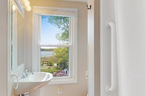 baño con lavabo y ventana en Sunset Cove Retreat, en Wareham