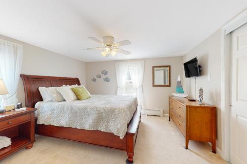 a bedroom with a bed and a ceiling fan at Sunset Cove Retreat in Wareham