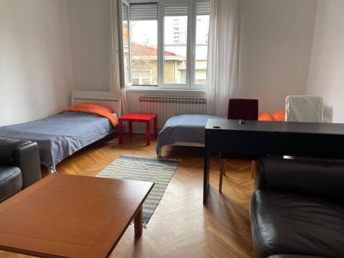 uma sala de estar com duas camas e uma mesa em Apt. 80 m2, wifi, jacuzzi, 5 guests, 10min center em Zagreb