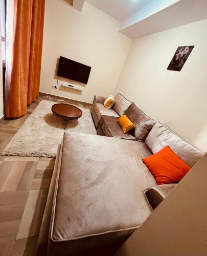 a living room with a couch and a flat screen tv at Urbantech 1 Bedroom Luxurious BnBs' in Nakuru