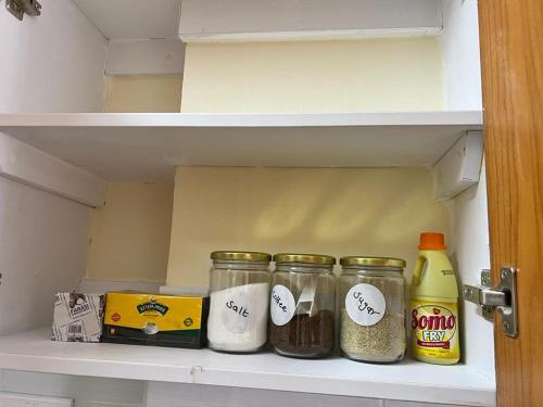 a refrigerator shelf with four jars of food in it at Urbantech 1 Bedroom Luxurious BnBs' in Nakuru