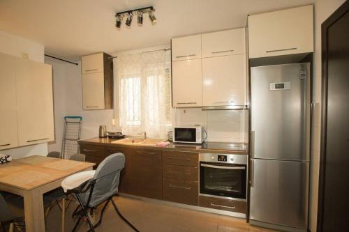 a kitchen with a stainless steel refrigerator and a table at My Greko Home in Neoi Epivates