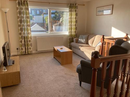 a living room with a couch and a tv at Edgemont Annexe Oban in Oban