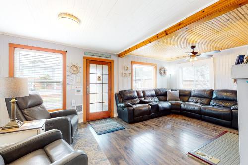 a living room with leather couches and a couch at Ocean Shells Cottage in Rockaway Beach