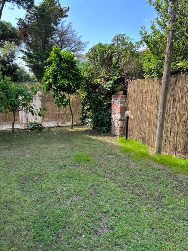 a backyard with a wooden fence and a yard at Jo's House in Calambrone