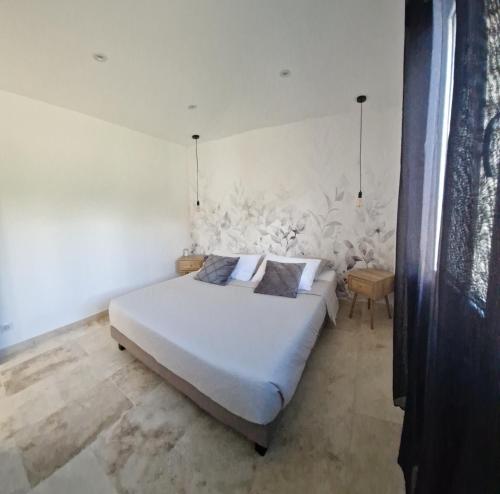 una camera con un letto bianco e una parete bianca di Domaine U Filanciu - Maison Chiara avec piscine - Centre Corse a Moltifao