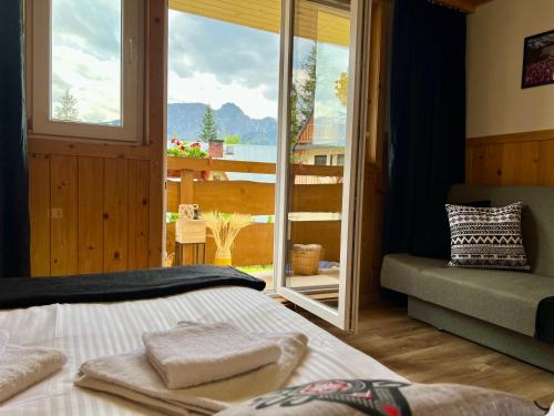 a bedroom with a bed and a view of a balcony at Mały Bystry Domek in Kościelisko