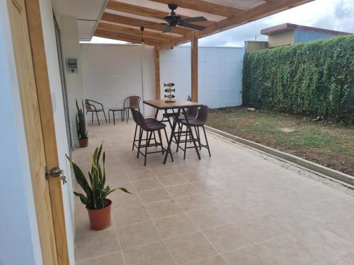 patio con mesa y sillas y ventilador de techo en Casa Playa Bejuco, en Esterillos Este