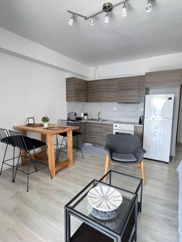 a kitchen and living room with a table and chairs at Sunny Seaside Cozy Home in Piraeus