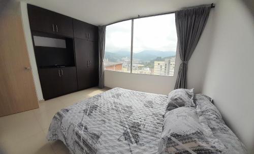 1 dormitorio con cama y ventana grande en Casa Colibrí Hospedaje Manizales a 2 min del Cable y 1 min Zona G, en Manizales