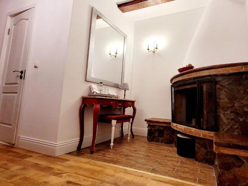 Zimmer mit einem Spiegel, einem Tisch und einem TV in der Unterkunft Carpathia Magic in Peştera
