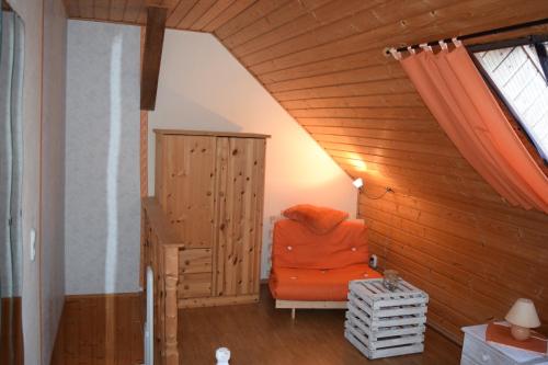 an orange chair in the corner of a room at FeWo Gartenblick in Krummin