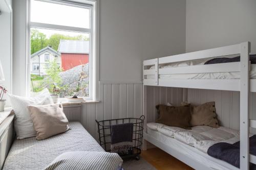 1 dormitorio con 2 literas y ventana en Exclusive house with private boathouse, en Nösund