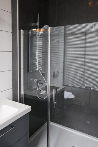 a bathroom with a sink and a glass shower at Hotel Sleep-Inn Box 5 in Nijmegen