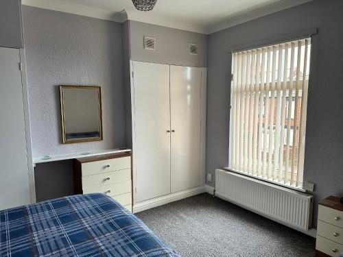 Schlafzimmer mit einem Bett, einer Kommode und einem Spiegel in der Unterkunft Cosy house in Wombwell in Barnsley