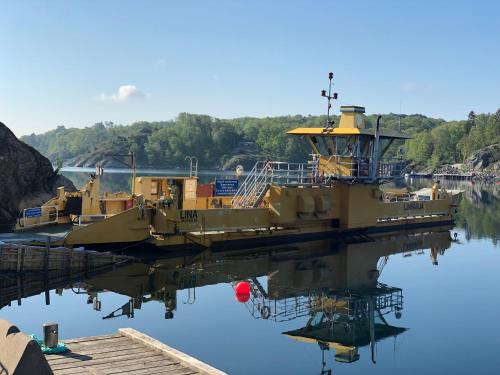 a boat docked at a dock in the water at Exclusive house with private boathouse in Nösund
