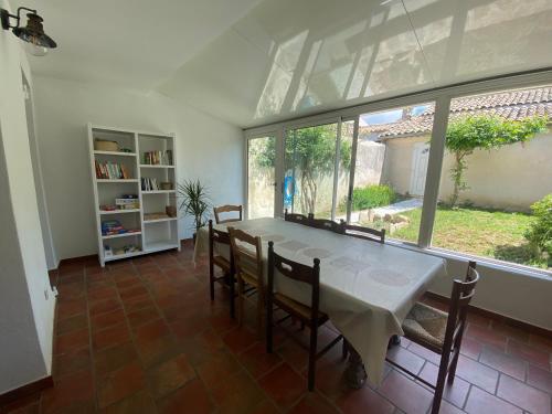 une salle à manger avec une table et des chaises et une fenêtre dans l'établissement Les Volets Bleus, à Malaucène