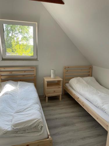 two beds in a room with a window at Winnica Bracia Petrasz 