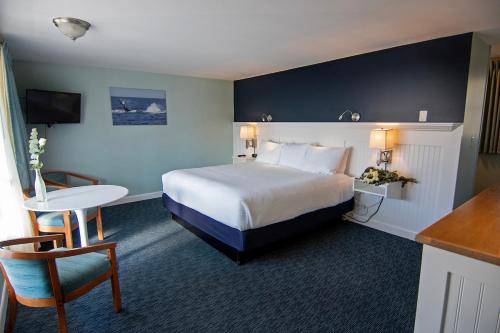 a hotel room with a bed and a table and chair at Cape Colony Inn in Provincetown