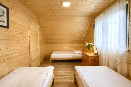 ein kleines Zimmer mit 2 Betten und einem Fenster in der Unterkunft Kolorowe Domki Rewal, 200m do plaży, morza Uwielbiany przez rodziny z dziećmi in Rewal