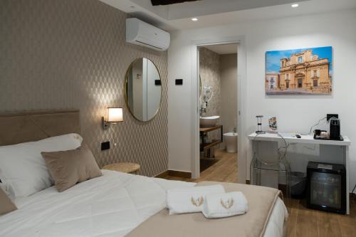 a bedroom with a bed and a bathroom with a sink at Sofi' Center Rooms in Sciacca