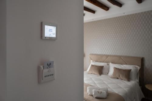 a bedroom with a bed with a clock on the wall at Sofi' Center Rooms in Sciacca