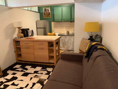 un salon avec un canapé et une cuisine dans l'établissement Studio indépendant /2 personnes, au Bugue