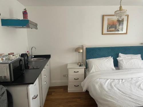 um quarto com uma cama, um lavatório e um micro-ondas em La Mignonne Aketoise em Peterborough