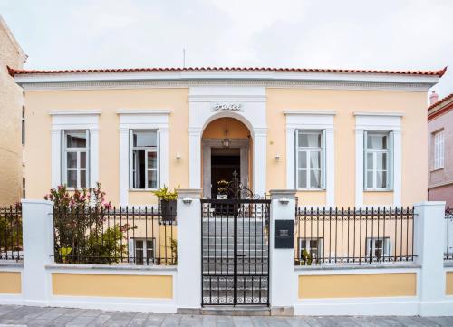 een huis met een hek ervoor bij Archontiko Eleni Hotel in Ándros