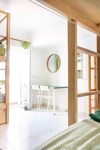 a bedroom with a dining room table and chairs at Surf Yoga Ericeira Guest House in Ericeira