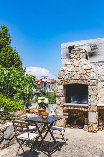 a picnic table in front of a stone fireplace at Guest house Otto in Punat