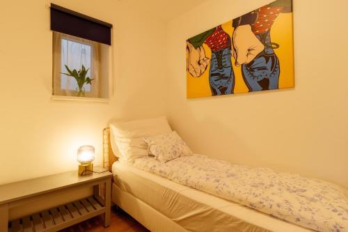 een slaapkamer met een bed en een foto aan de muur bij Apartmany Tachov - First Floor in Tachov
