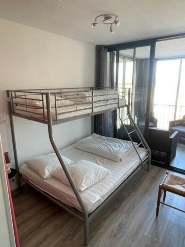 une chambre avec deux lits superposés dans une pièce dans l'établissement le Barcarès appartement bord de mer, au Barcarès