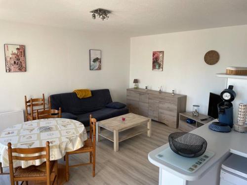 een woonkamer met een bank en een tafel bij le Barcarès appartement bord de mer in Le Barcarès