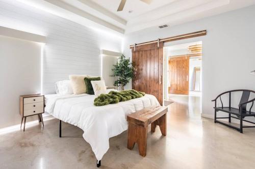 una camera da letto bianca con un letto grande e un tavolo di Downtown Modern Farmhouse-Pool- Sleeps 12 a San Antonio